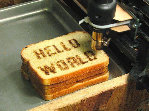 "Hello World!" is often used to illustrate basic syntax of a programming language and to verify that a system is operating correctly. Here, a device prints the sentence onto brioche toast.